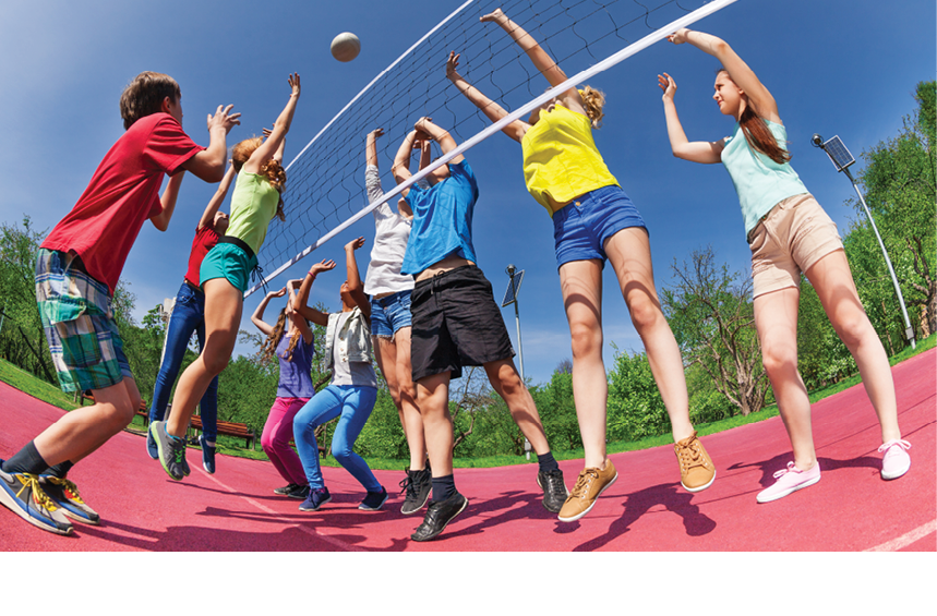 View from below of teens playing volleyball